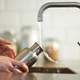 hands in sink washing water bottle